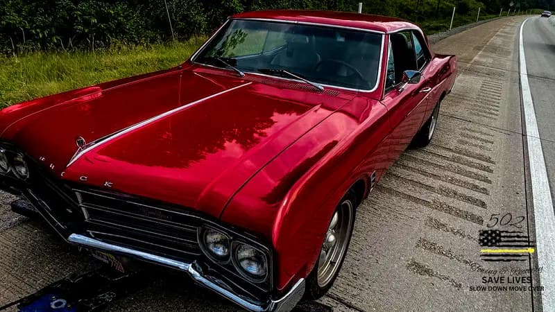 A classic muscle car secured on a flatbed