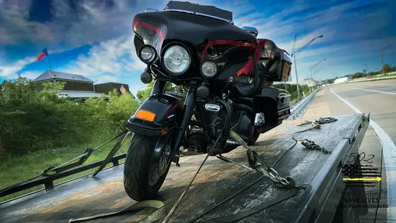 A touring motorcycle secured with soft straps and a wheel chock