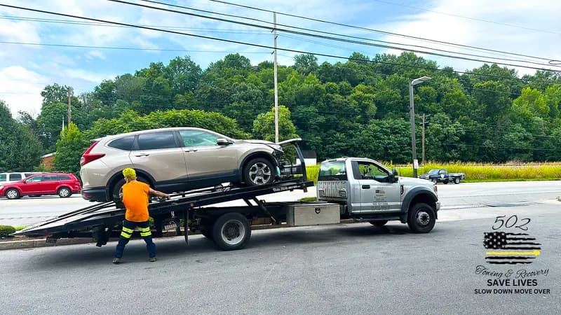 Loading a vehicle onto a flatbed on a Louisville street