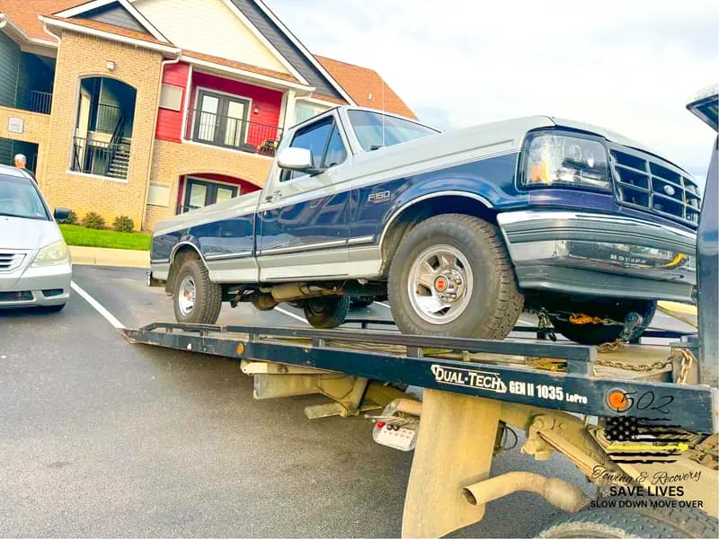 A pickup truck loaded on a flatbed carrier